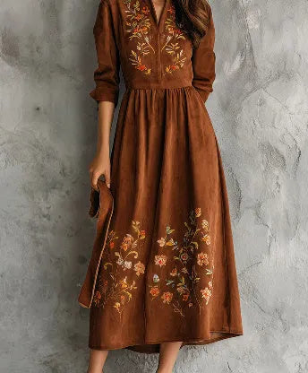 Brown suede-effect midi dress with detailed floral embroidery on the skirt, shown on a model.