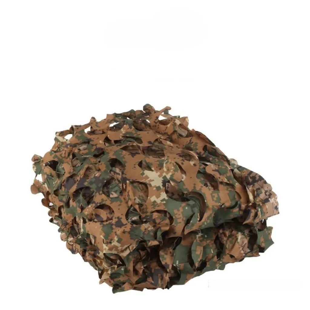Green camouflage netting on a forest floor showing a multi-spot camouflage pattern.