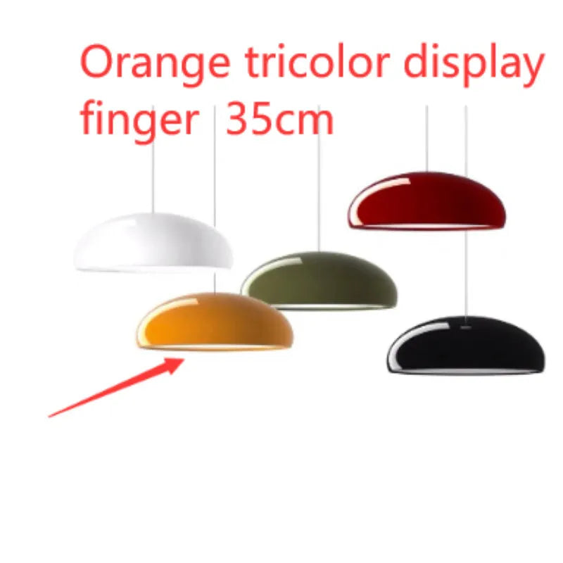 Orange iron Danish-style pendant lamp with adjustable cable above a restaurant table.