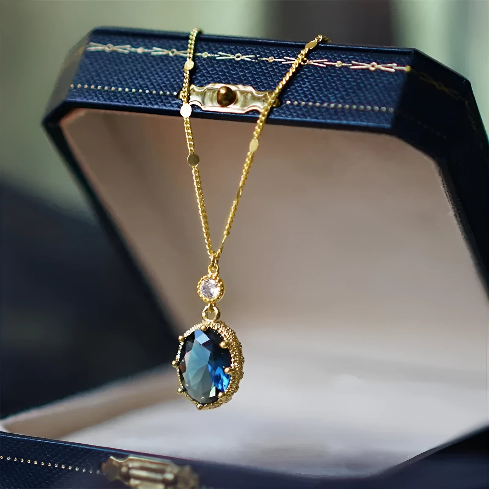 Gold geometric pendant necklace with a French retro design on a model.