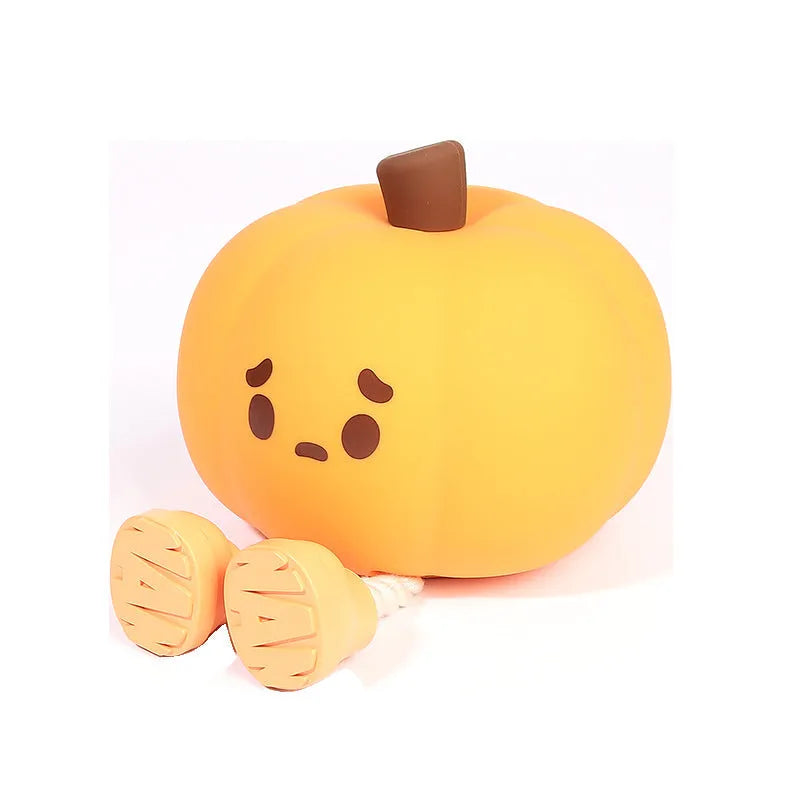 Soft orange silicone pumpkin-shaped night light with a gentle glow, sitting on a surface.