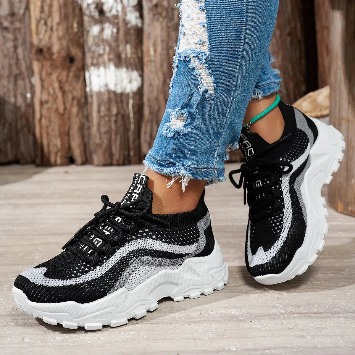 Women's casual sports shoes with mesh upper and lace-up front in black and white colour