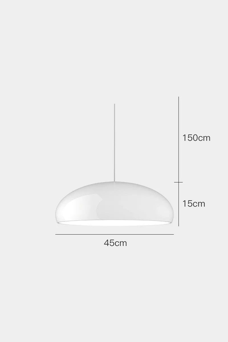 Orange iron Danish-style pendant lamp with adjustable cable above a restaurant table.