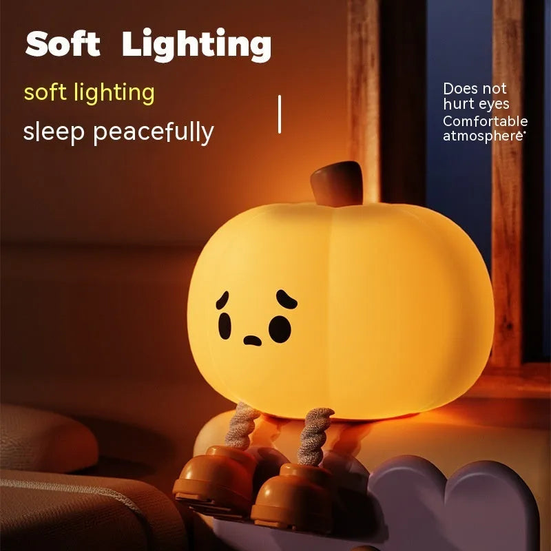 Soft orange silicone pumpkin-shaped night light with a gentle glow, sitting on a surface.
