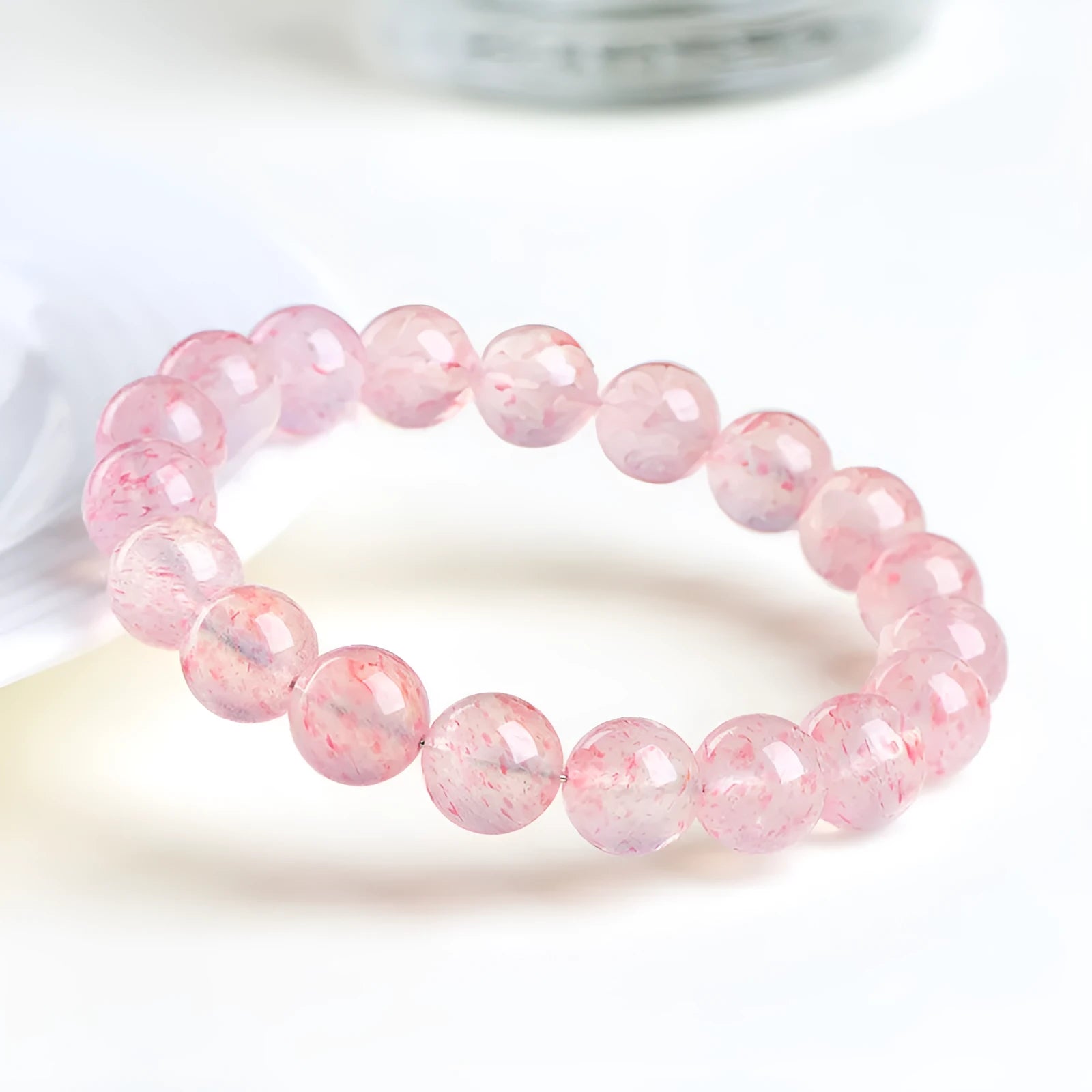 Strawberry quartz crystal bracelet with 10-10.8mm white water geometry beads on wrist