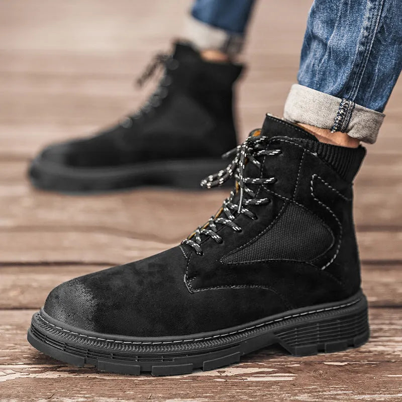 Men's ankle-high Martin boots in frosted grey leather with a thick rubber sole and round toe on a wooden floor.