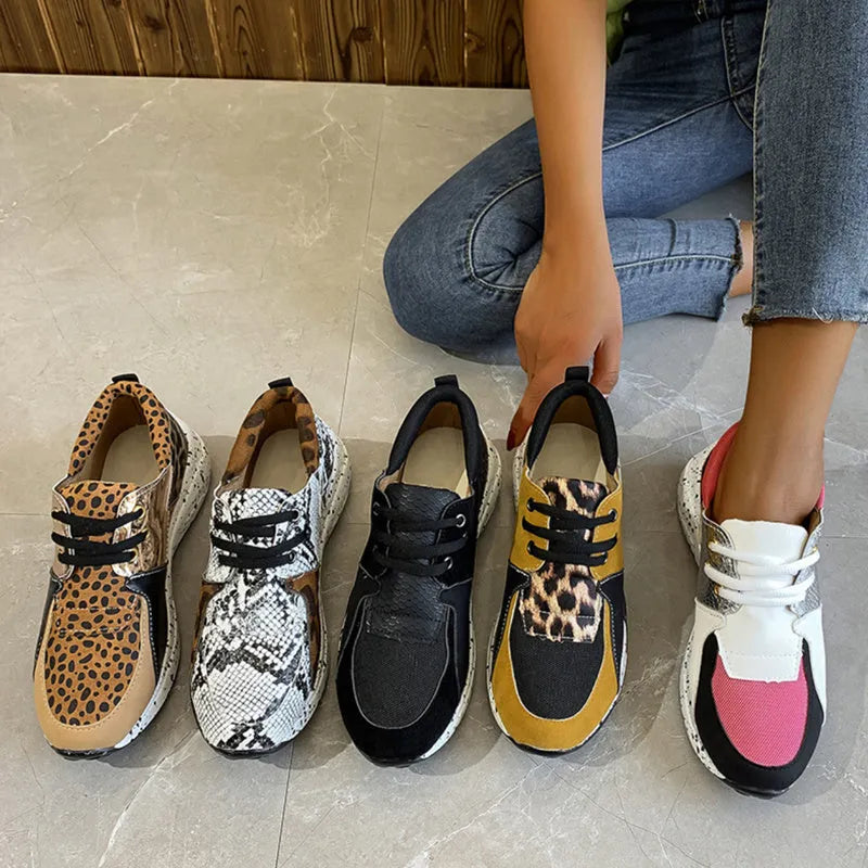 Women's black suede casual sneakers with a low wedge heel and round toe on a white background.