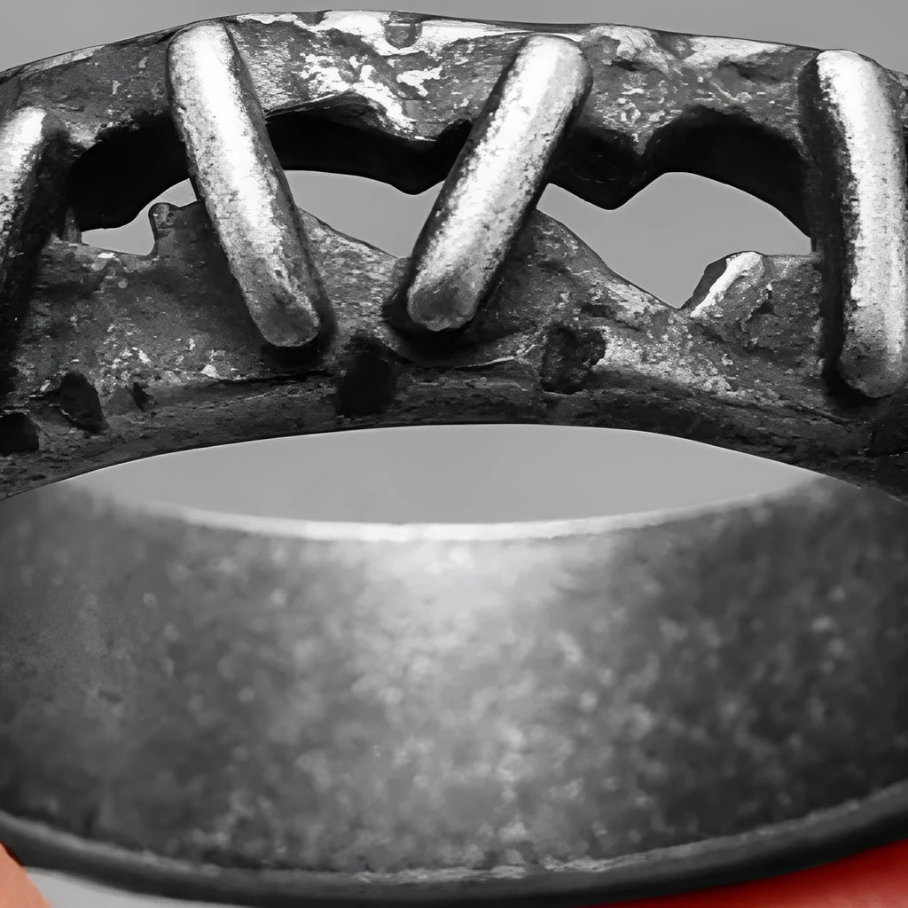 Close-up of a dark stainless steel double ring with punk-inspired stitching details on a finger.