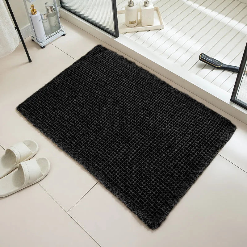 A beige checkered non-slip polyester bathroom carpet on a tiled floor.