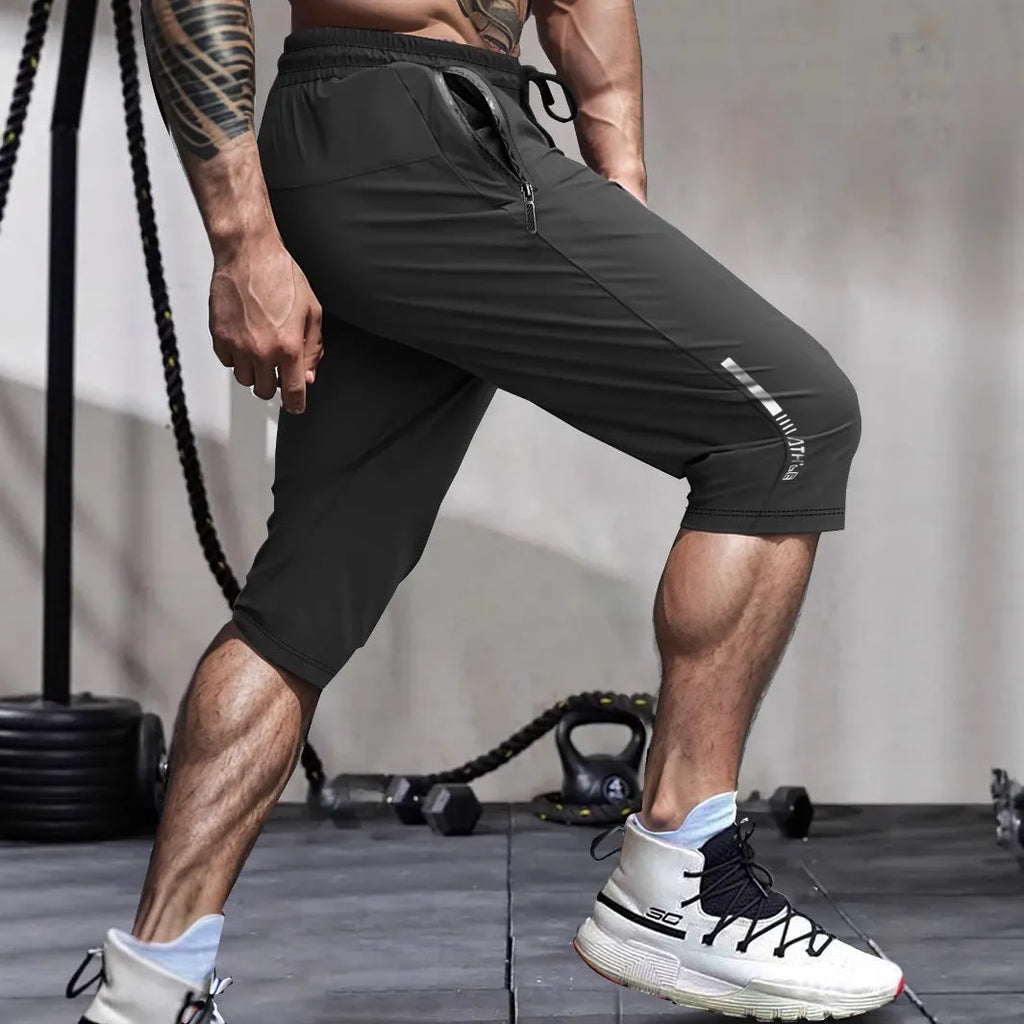 Man wearing grey cropped ice silk sports pants with a straight leg and elasticated waist.