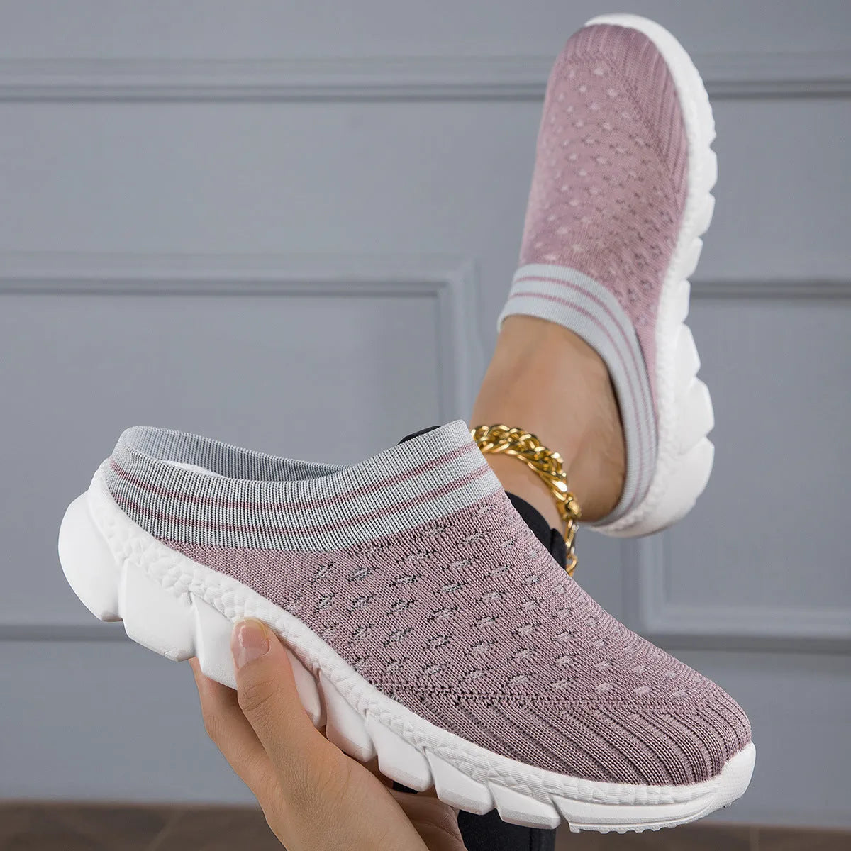 Women's black Flyknit semi-slipper casual shoe with striped pattern and hollow-out design on a white background.
