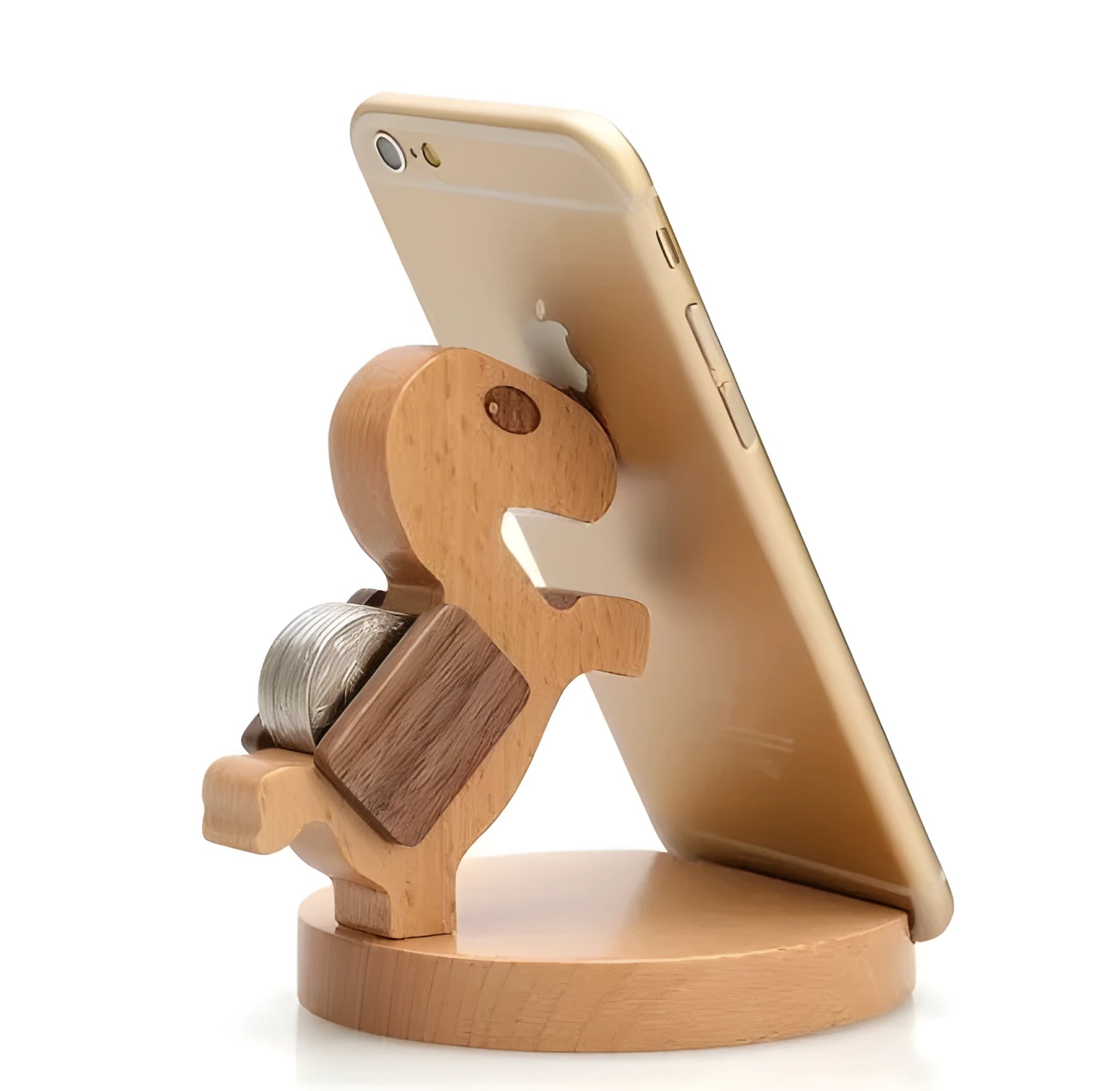 Solid beech wood mobile phone stand with a resin cow figurine and a slot for holding coins on a wooden desk.