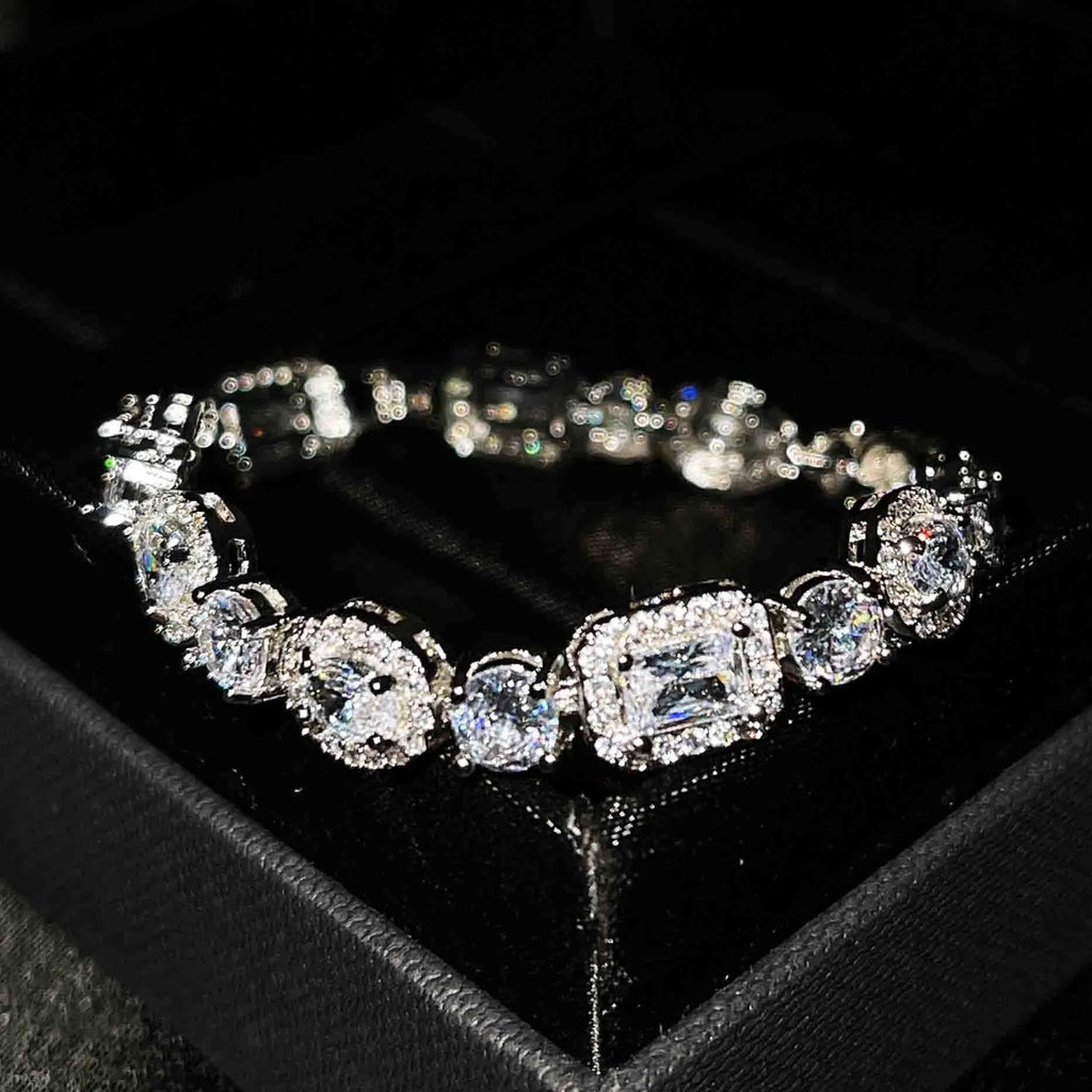 Close-up of a women's geometric silver bracelet with sparkling inlaid zircon stones and a lobster clasp.