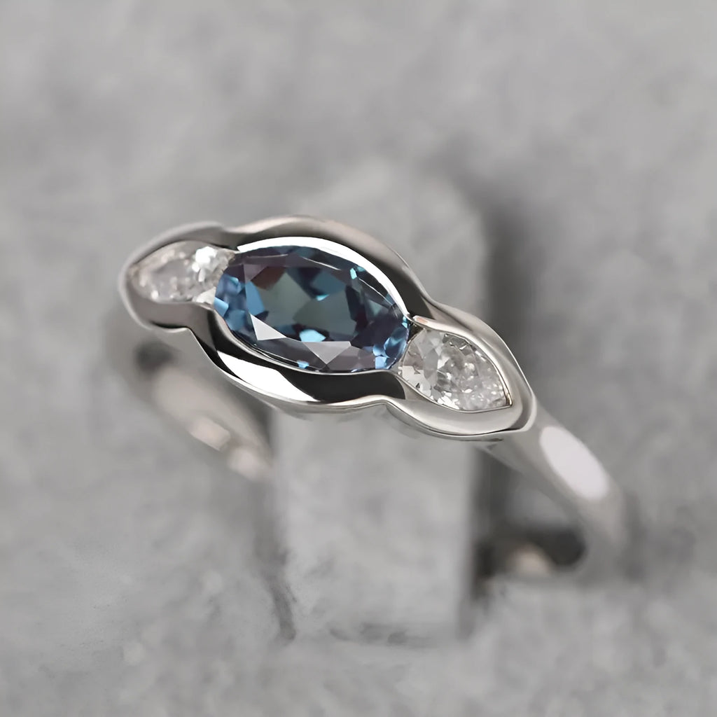 Geometric ellipse copper ring with inlaid zircon stone in a white gold tone colour.