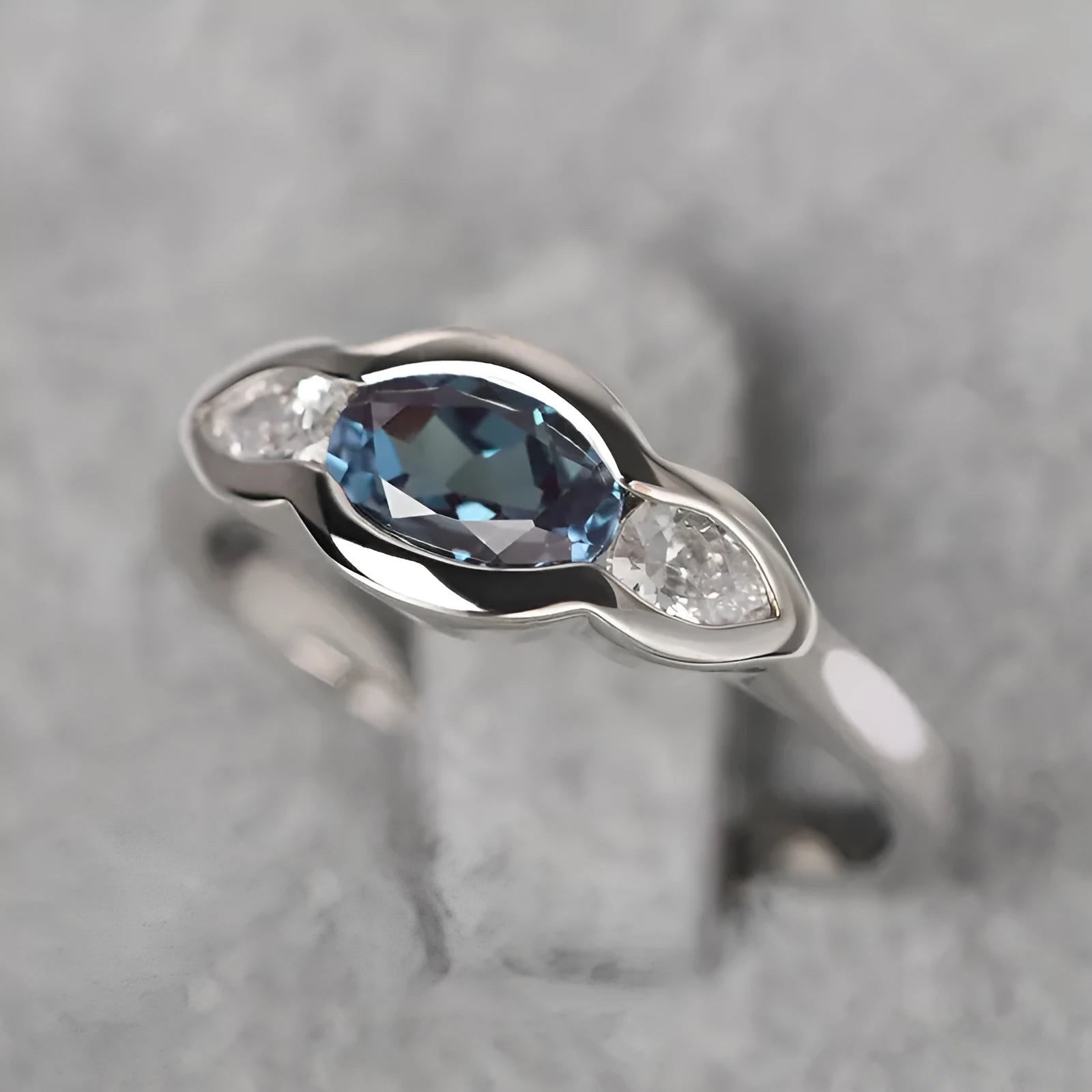 Geometric ellipse copper ring with inlaid zircon stone in a white gold tone colour.