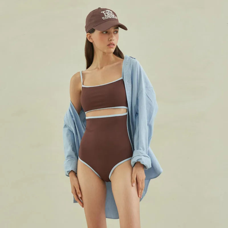 Brown women's triangle one-piece nylon swimsuit on a hanger.