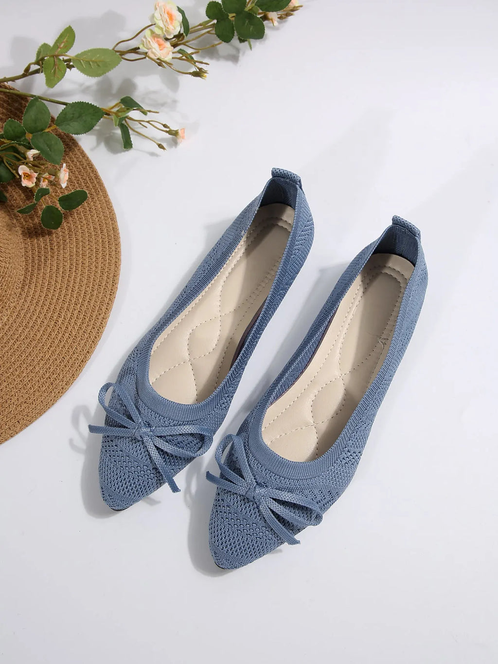 Women's knitted flat loafers with a bow and pointed toe in blue, shown from the side.