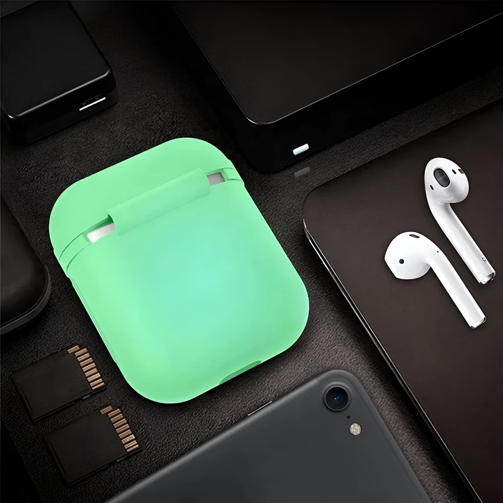Glow-in-the-dark silicone flip-top protective case for Apple AirPods on a dark background.