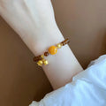Caramel coloured electroplated women's bracelet with Lily flower design in mixed materials.