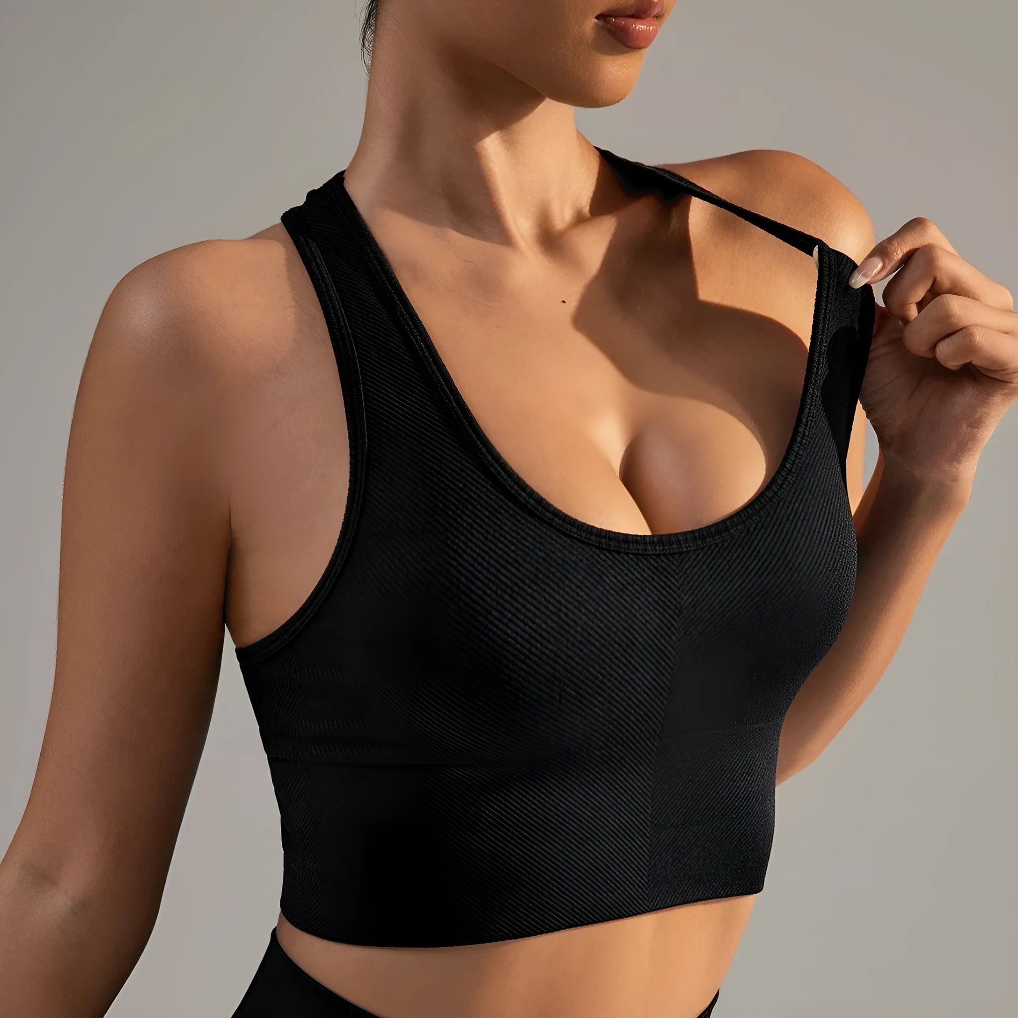 Black women's sports bra with cross-back design and moulded cups for yoga and running.