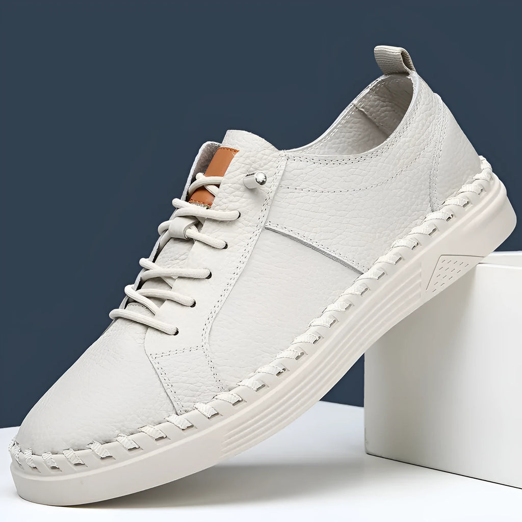 Men's beige and black cowhide leather sneakers with round toe and visible stitching on a white background.