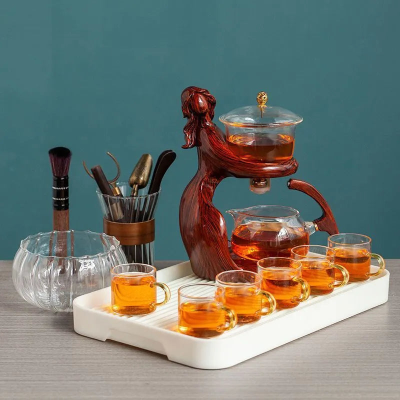 Maid semi-automatic glass teapot set with heat-resistant base and stainless steel tea infuser on a tea tray