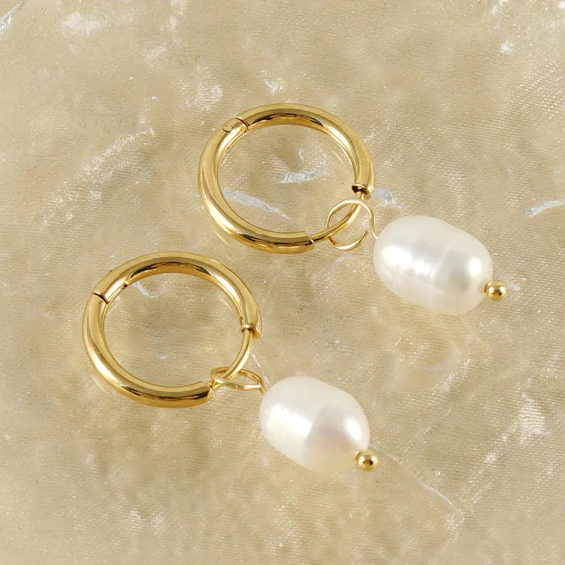 Gold geometric women's earrings with a pearl detail on a white background
