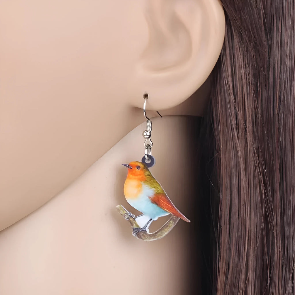 Blue, yellow, and white titmouse bird acrylic pendant drop earrings on a white background.