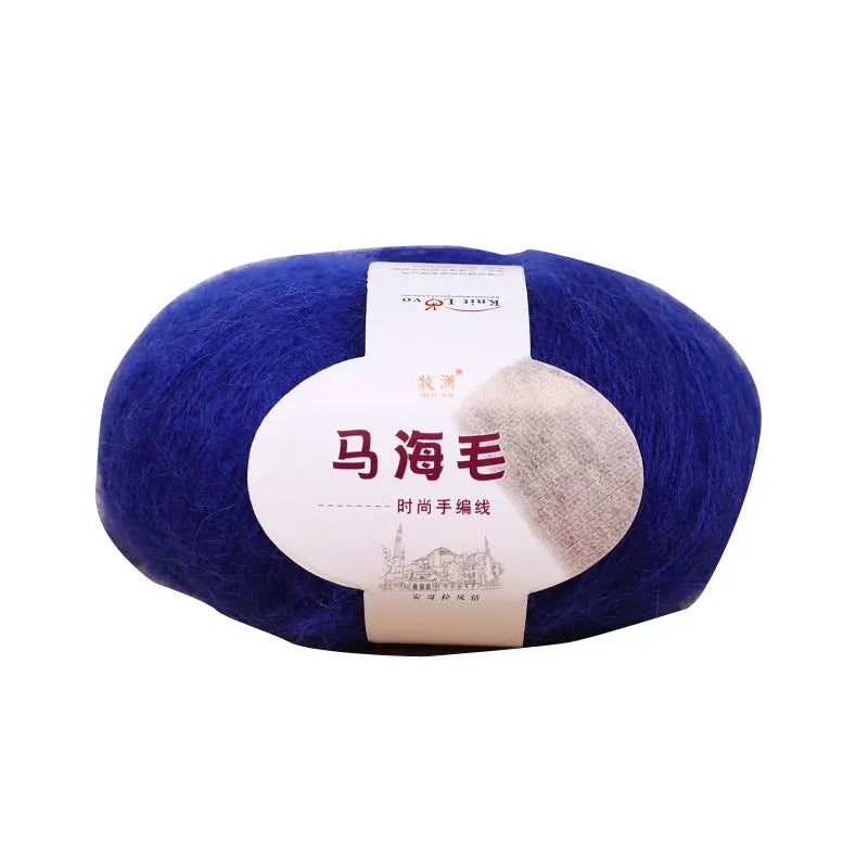 Single 100g ball of mohair yarn in a chosen colour next to a hand-woven light grey scarf sample.