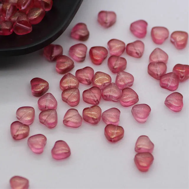 Twenty transparent Czech glass love heart spacer beads in assorted colours including aurora purple and peach gold.