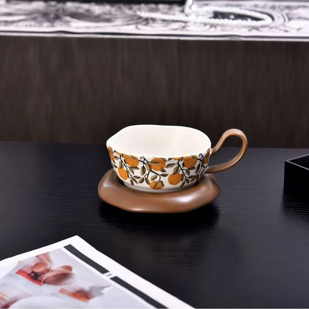 Antique style ceramic coffee cup and saucer with 210ml capacity, shown in black pomegranate and orange Citrofortunella design options.