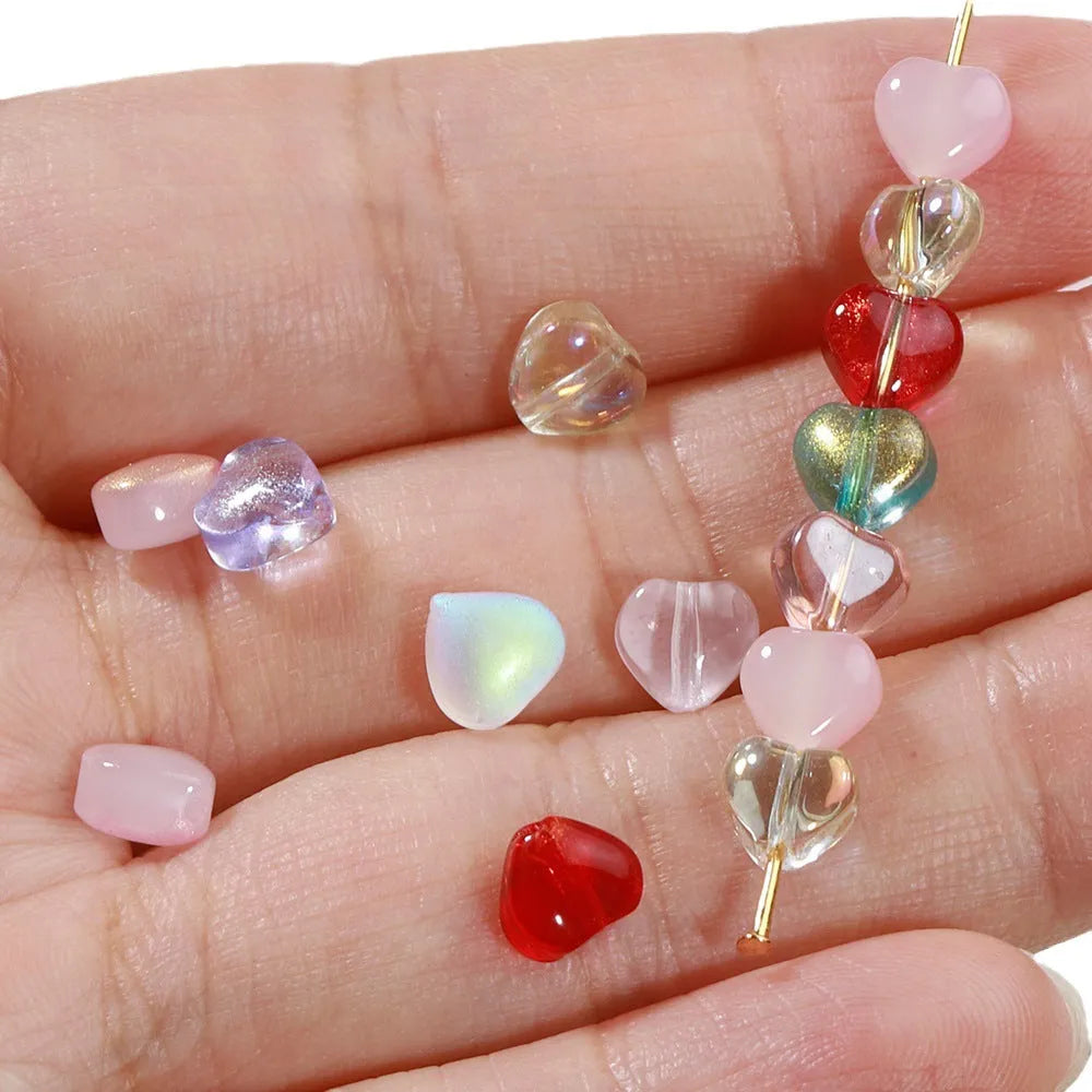 Twenty transparent Czech glass love heart spacer beads in assorted colours including aurora purple and peach gold.