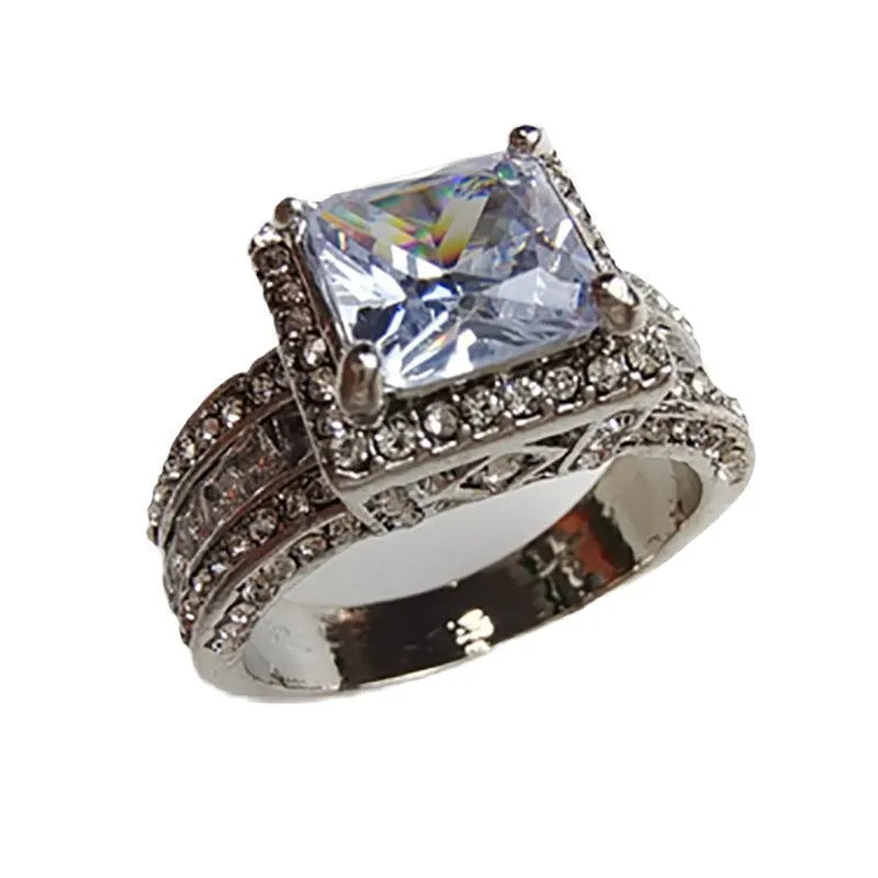 Geometric round silver fashion ring for women in gold or white tone on a grey background.