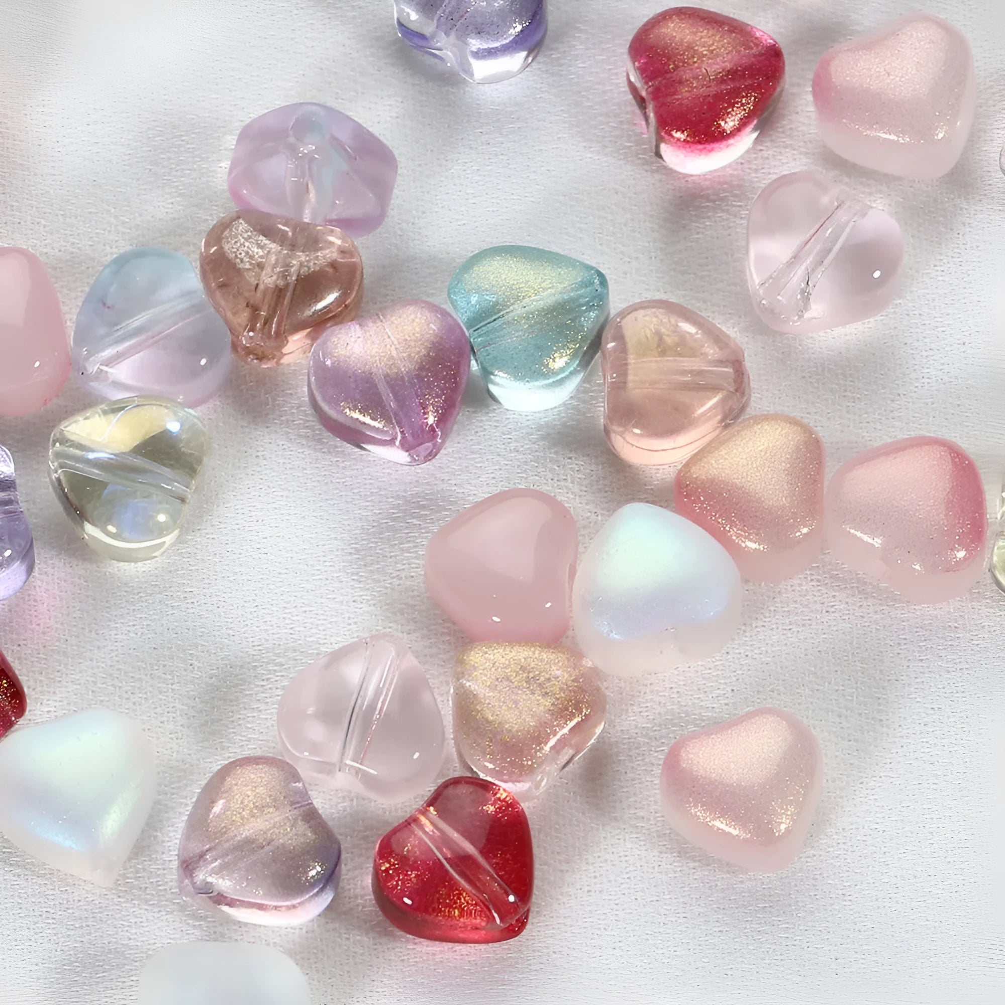 Twenty transparent Czech glass love heart spacer beads in assorted colours including aurora purple and peach gold.