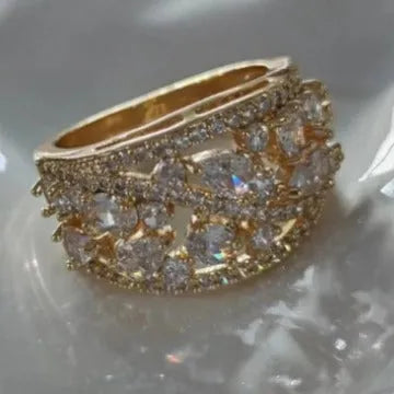 Women's round hollow copper fashion ring on a hand, showing gold and platinum finish options with blue and white accents.