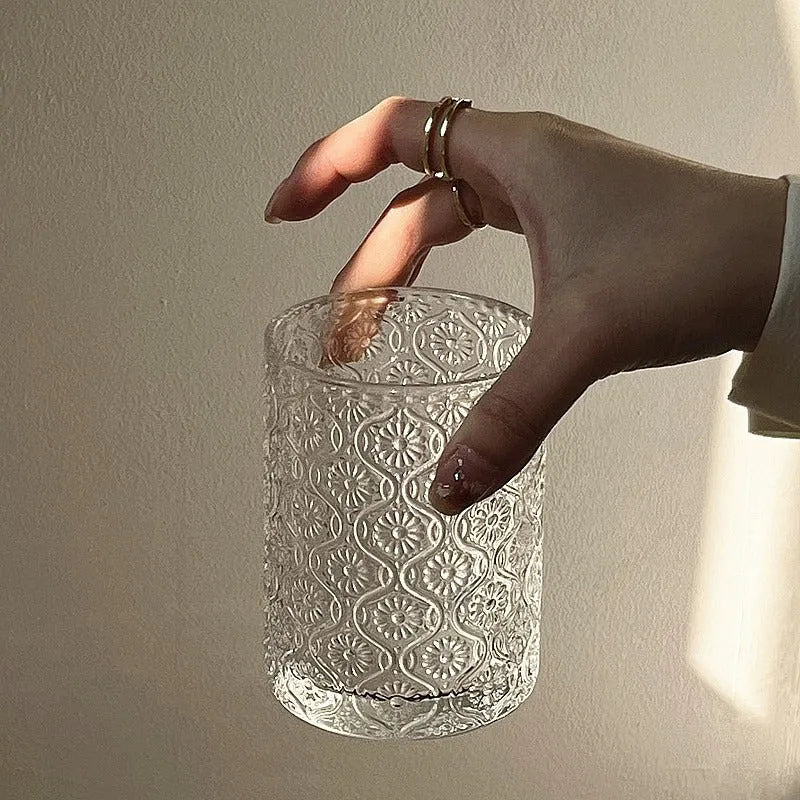 Begonia patterned glass drinking cup in short and tall sizes on a table.