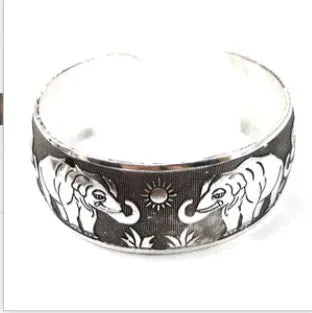 Openwork ethnic bracelet with carved Miao silver finish showing elephant design detail on wrist.