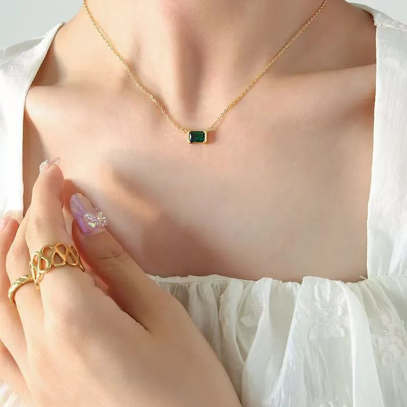 Gold geometric quadrilateral pendant necklace with inlaid cubic zirconia stones on a matching chain.