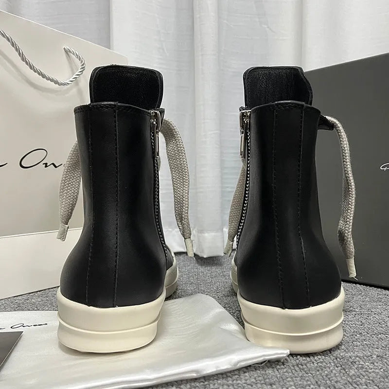 Black high-top genuine leather boots with side zip detail on a white background.