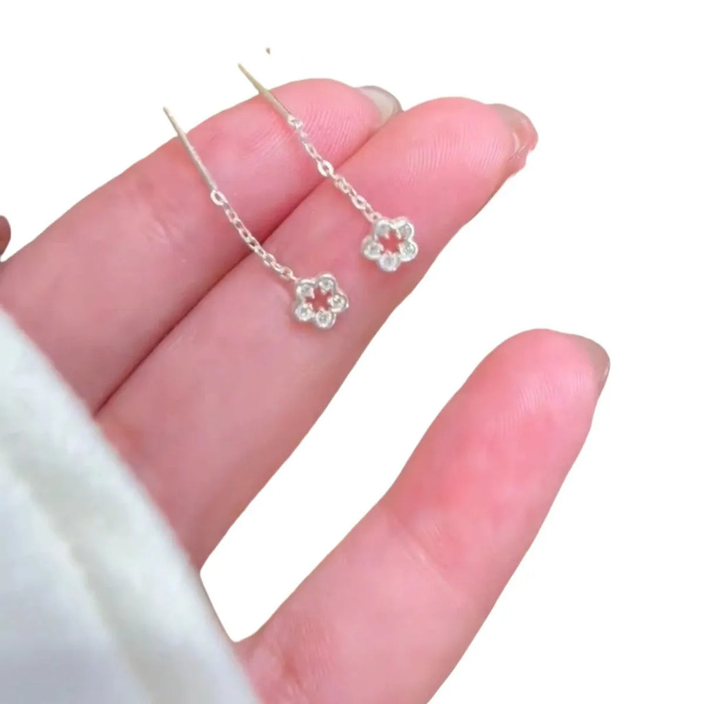 Silver hollow flower hanging earrings with petal detailing and needle fastening