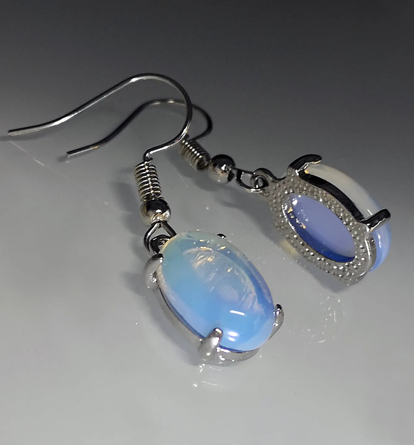 A pair of retro-style drop earrings with a moonlight opal centre on an electroplated alloy setting.