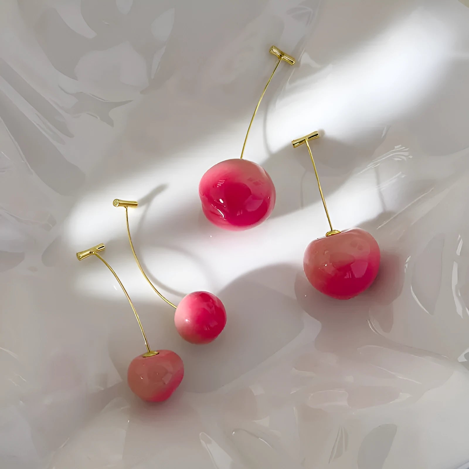 Pair of peach-shaped acrylic fashion earrings with copper posts on a white background.