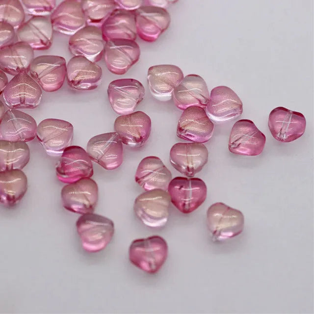 Twenty transparent Czech glass love heart spacer beads in assorted colours including aurora purple and peach gold.