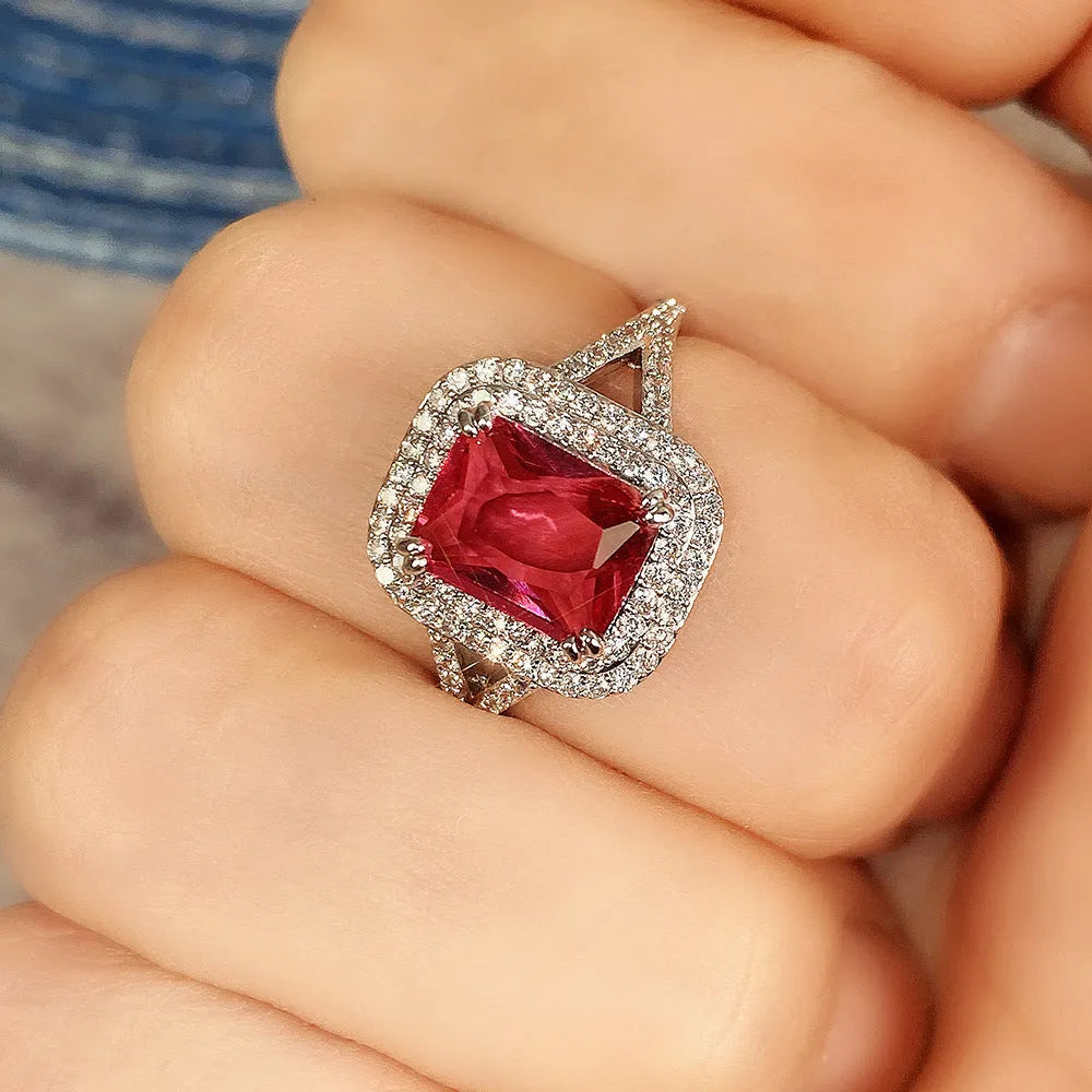 Women's geometric copper ring with a square red rhinestone on a hand.