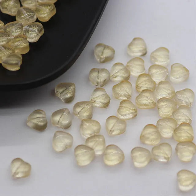Twenty transparent Czech glass love heart spacer beads in assorted colours including aurora purple and peach gold.