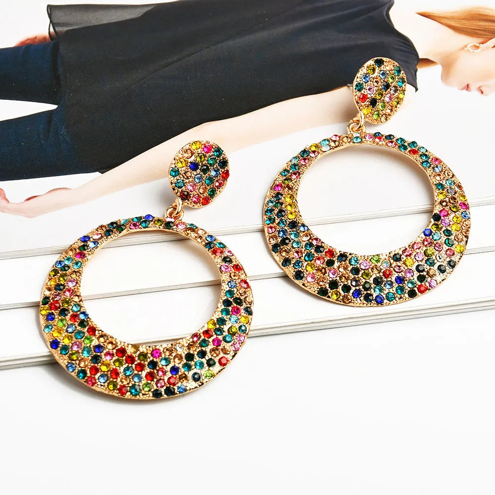 A pair of large round pendant earrings with a cartoon style in a colour metal alloy finish.