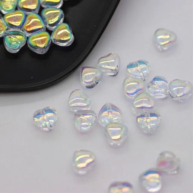 Twenty transparent Czech glass love heart spacer beads in assorted colours including aurora purple and peach gold.