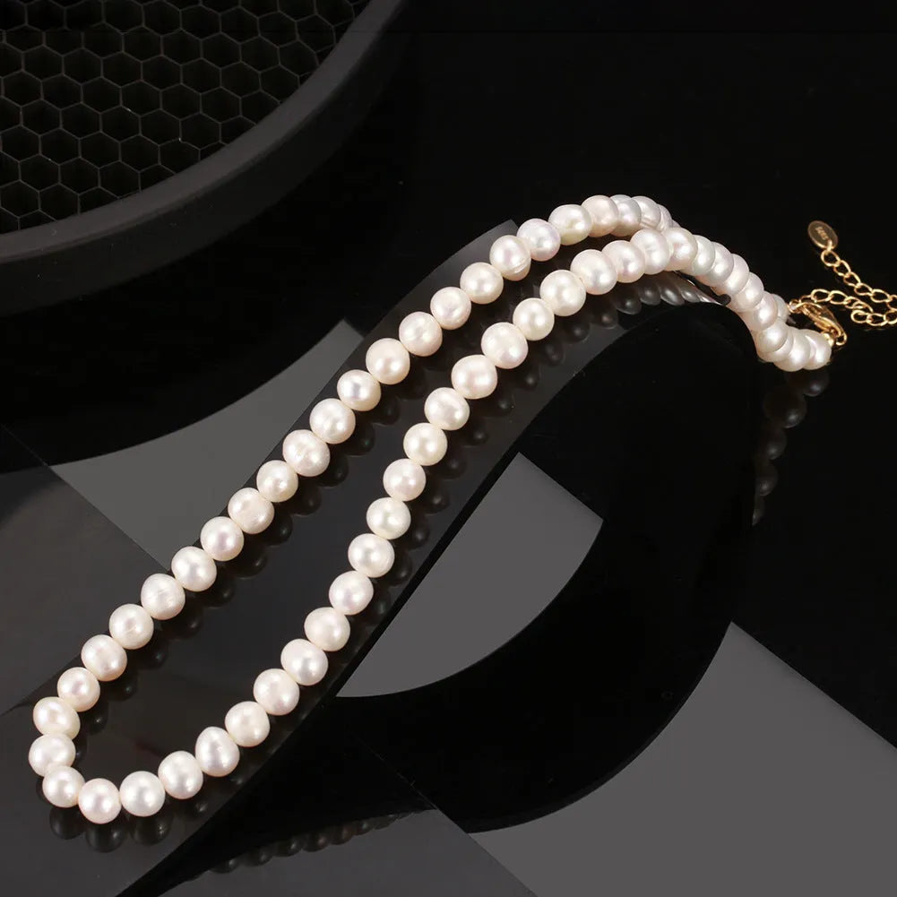 Close-up of a silver adjustable necklace with a single natural freshwater pearl pendant.