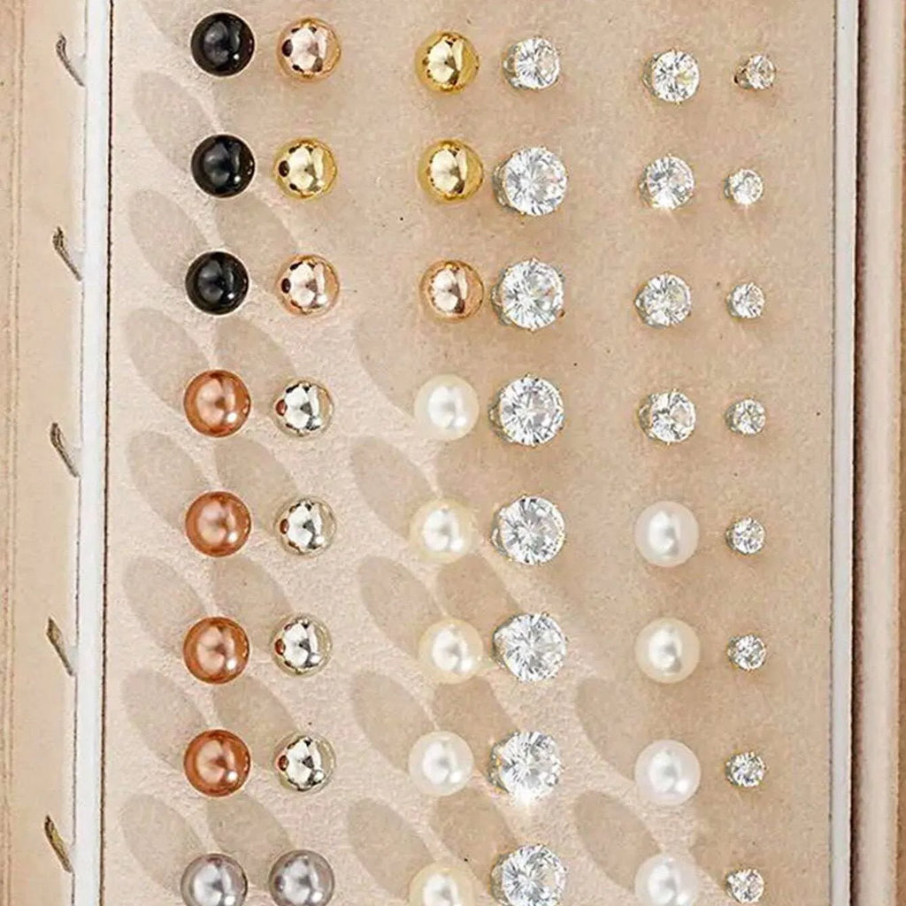 108 gold and yellow geometric alloy earrings with pearl details laid out flat.