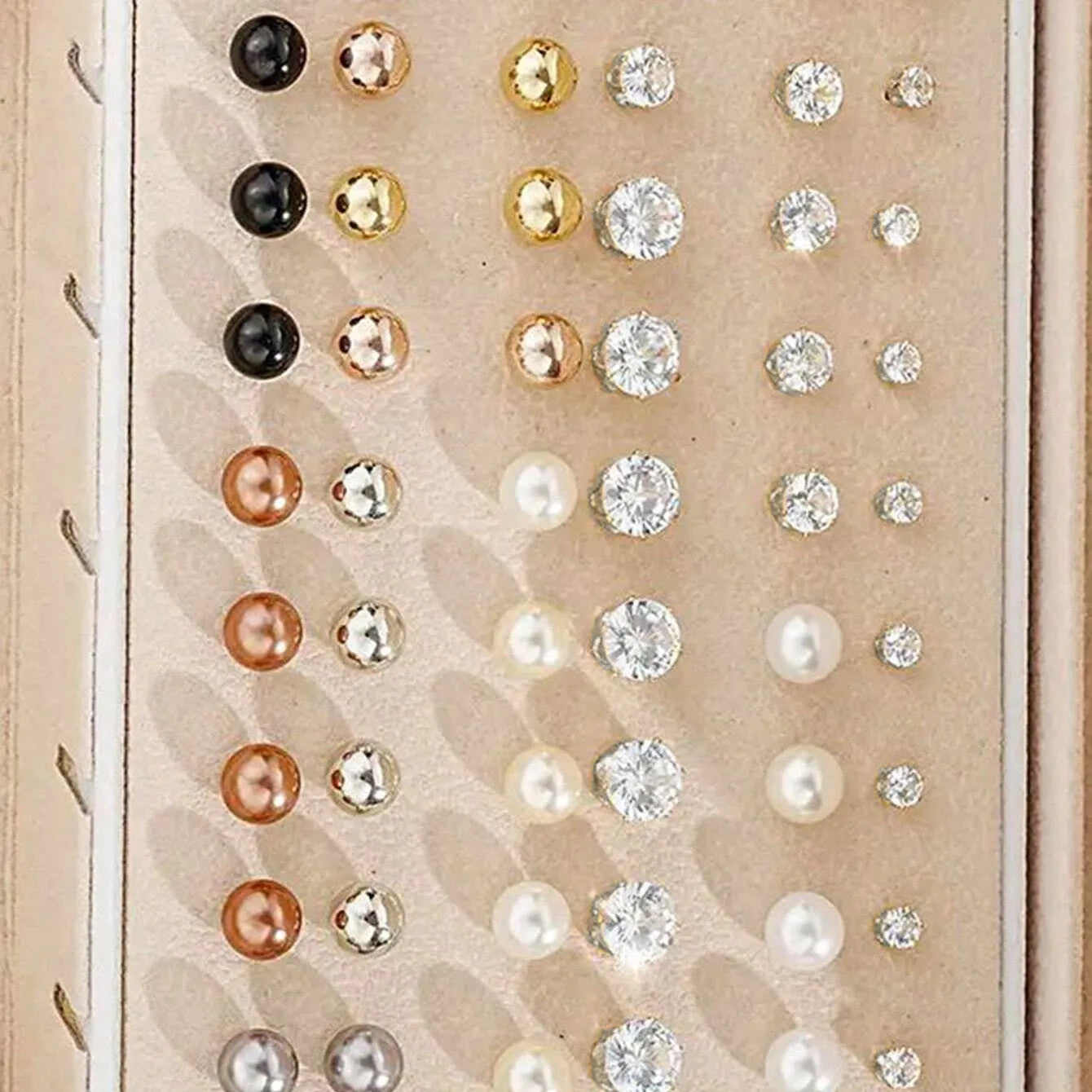 108 gold and yellow geometric alloy earrings with pearl details laid out flat.